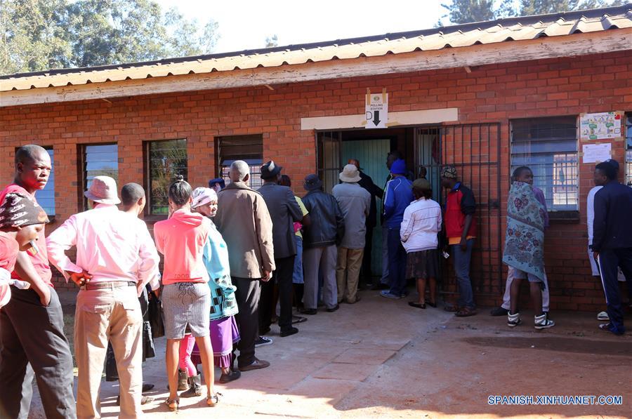 Personas permanecen en fila para emitir sus votos en Kuwadzana, Harare, Zimbabue, el 30 de julio de 2018. Los zimbabuenses empezaron el lunes a ejercer su derecho al sufragio en las primeras elecciones presidenciales desde que el ex presidente Robert Mugabe renunciara a su cargo en noviembre de 2017. (Xinhua/Zhang Yuliang)