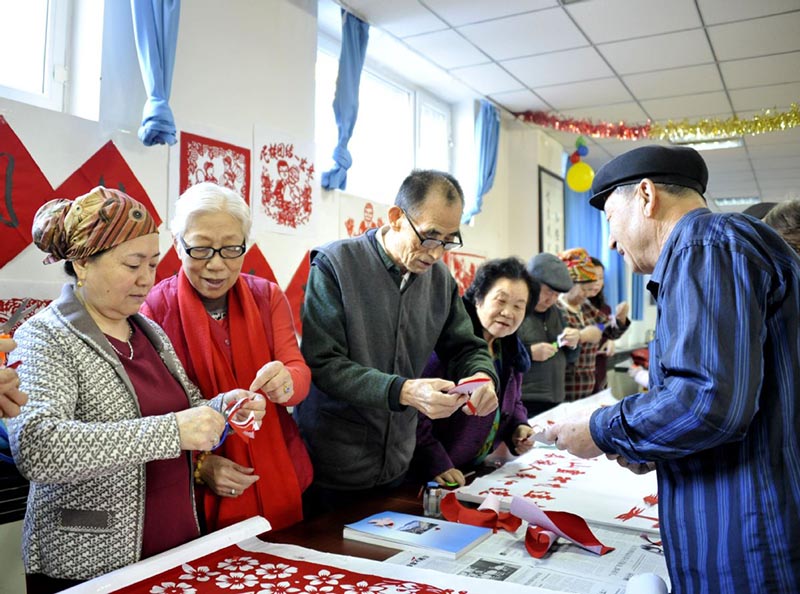 Hao Xianyi entrena a los entusiastas del corte de papel. [Foto de Xiao Ying / for China Daily]