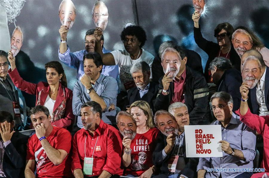 El presidente del Partido de los Trabajadores (PT), Gleisi Hoffman (c), y otros partidarios del PT sostienen máscaras del expresidente de Brasil, Luiz Inácio Lula da Silva, durante la Convención Nacional del PT, en Sao Paulo, Brasil, el 4 de agosto de 2018. De acuerdo con la prensa local, la candidatura por el PT para las elecciones presidenciales del expresidente de Brasil que se encuentra detenido en Curitiba, Luiz Inácio Lula da Silva, fue lanzada oficialmente durante el congreso. (Xinhua/Rahel Patrasso)