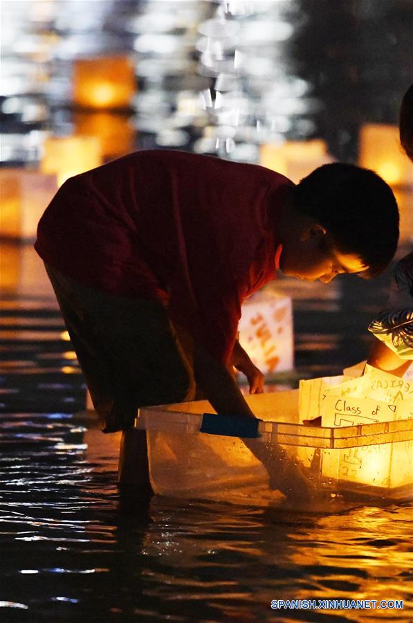 MARYLAND, agosto 5, 2018 (Xinhua) -- Imagen del 4 de agosto de 2018 de un ni?o colocando una linterna de agua durante un festival de linternas de agua, en el Puerto Nacional, en Maryland, Estados Unidos. Las linternas fueron puestas a flote el sábado para iluminar el Río Potomac con motivo del Festival de Linternas de Agua, creando una muestra espectacular de luces. (Xinhua/Liu Jie)