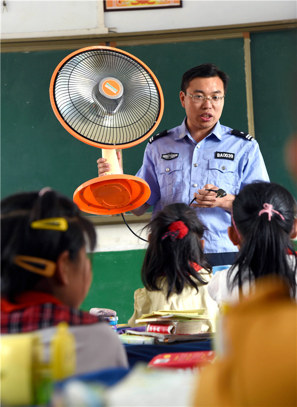 Un guardia de seguridad demuestra el uso seguro de la electricidad, Zaozhuang, provincia de Shandong. (Foto: Liu Mingxiang)