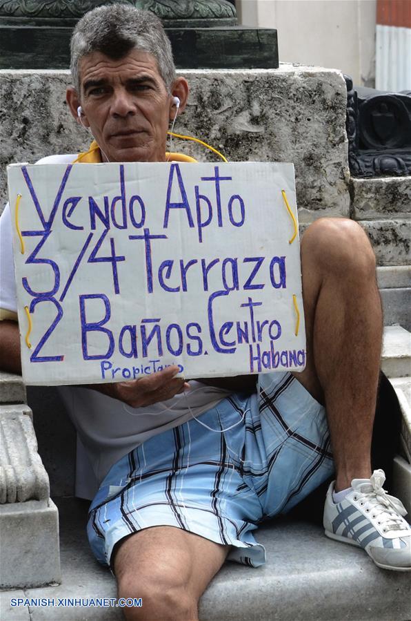 LA HABANA, octubre 7, 2018 (Xinhua) -- Imagen del 6 de octubre de 2018, de un hombre sosteniendo un cartel que promueve la venta de una vivienda, en la Bolsa de Permuta de Prado, en La Habana, Cuba. La conocida Bolsa de Permuta de Prado es un espontáneo lugar de intercambio de casas ubicado en el Paseo del Prado, una de las más viejas avenidas de la capital cubana. Allí, bajo la sombra de frondosos árboles, cientos de personas se dan cita todos los fines de semana en un informal mercado de viviendas donde, con carteles escritos a mano, muchos promueven los inmuebles que ofrecen y lo que necesitan. Los llamados "corredores de permutas" o "permuteros", como también se les conoce popularmente, son personas que se dedican a gestionar los intercambios de vivienda y cobran por esos servicios una parte del dinero involucrado en la transacción. (Xinhua/Joaquín Hernández)