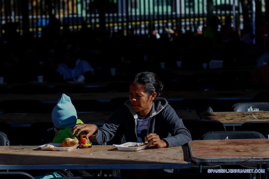 Una mujer y su hijo toman sus alimentos en el Estadio Jesús Martínez "Palillo", en la Ciudad Deportiva Magdalena Mixhuca, en la Ciudad de México, capital de México, el 5 de noviembre de 2018. Más de 2,200 migrantes centroamericanos de la masiva caravana que atraviesa México rumbo a Estados Unidos han llegado a la capital del país desde el domingo, informaron el lunes autoridades locales. A su entrada a la Ciudad de México, los cientos de familias con ni?os o adultos que viajan solos son dirigidos a un albergue que se habilitó en un estadio ubicado en el este de la urbe. (Xinhua/Francisco Ca?edo)