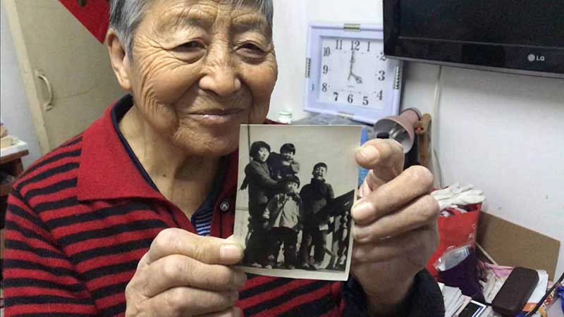 Zhang Ying, de 93 a?os, sostiene una foto de sus cuatro hijos que tomó en 1959 con su primera cámara. [Foto: Wang Kun/ Chinadaily.com.cn]