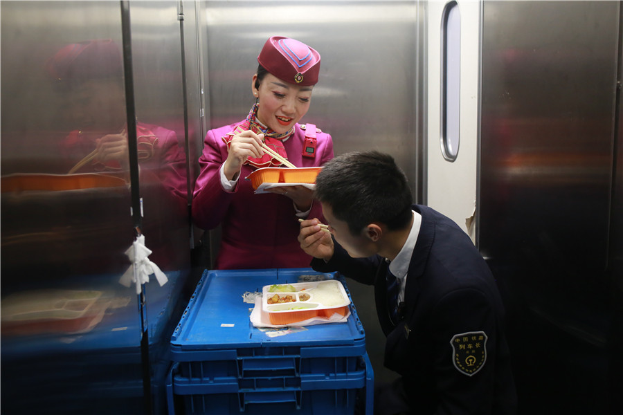 Liu Yuting y un compa?ero de servicio almuerzan durante una parada del tren. [Foto: proporcionada]