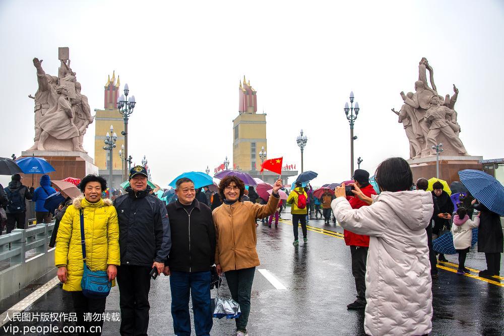 La gente en Nanjing desafía a la lluvia cruzando el recién renovado puente sobre el río Yangtse