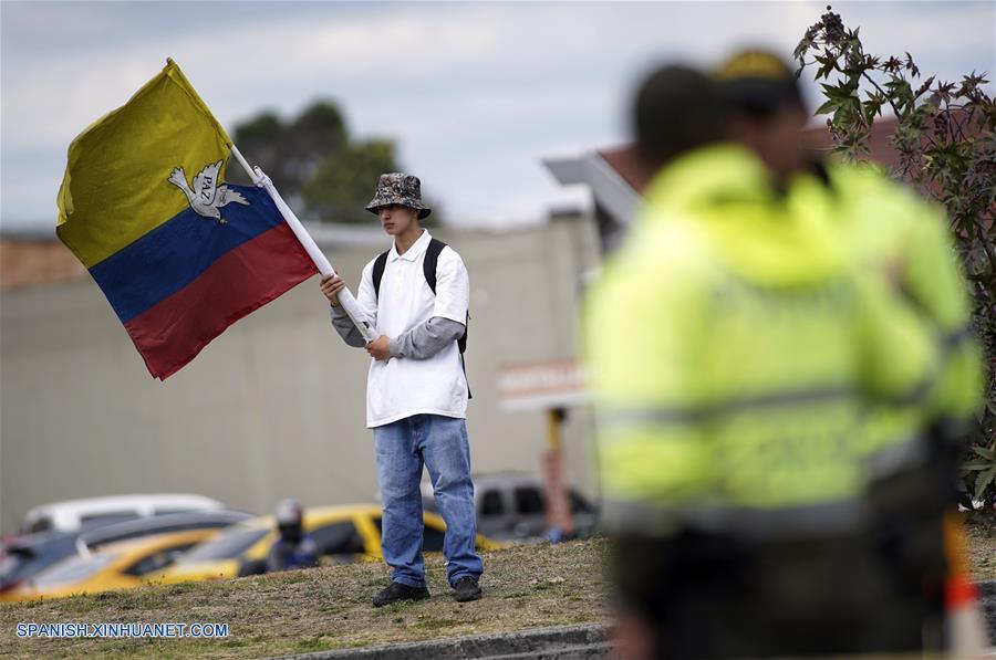 BOGOTA, enero 17, 2019 (Xinhua) -- Un residente ondea una bandera nacional colombiana frente a policías cerca del lugar donde se registró una explosión en el estacionamiento de la Escuela de Cadetes de Policía General Santander, en el sur de Bogotá, capital de Colombia, el 17 de enero de 2019. Aumentó a ocho el número de muertos y a más de 40 el de los heridos tras la detonación de un coche bomba en la Escuela de Cadetes de Policía General Santander, en la zona sur de Bogotá, Colombia, registrada el jueves. El alcalde de la capital colombiana, Enrique Pe?alosa, reportó que desconocidos ingresaron un coche bomba al sitio y que la onda explosiva destruyó varias fachadas. (Xinhua/Jhon Paz)