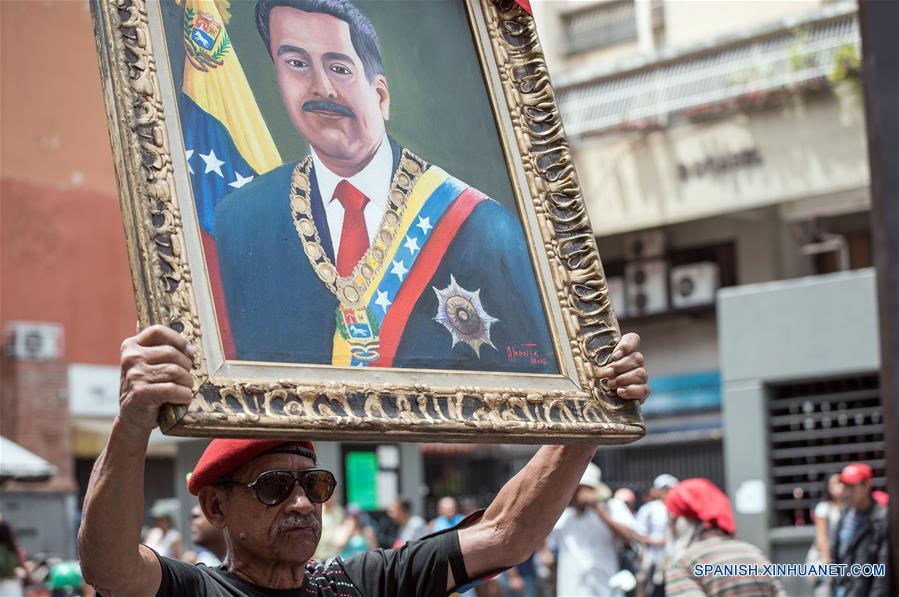 Un hombre sostiene un retrato del presidente venezolano, Nicolás Maduro, durante una marcha en apoyo al presidente de Venezuela, Nicolás Maduro, en Caracas, Venezuela, el 23 de marzo de 2019. El presidente venezolano, Nicolás Maduro, anunció el sábado durante un acto en Caracas la captura de un "poderoso jefe paramilitar colombiano" en el estado de Carabobo (centro-norte). (Xinhua/Marcos Salgado)