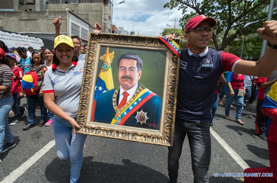 Personas sostienen un retrato del presidente venezolano, Nicolás Maduro, durante una marcha en apoyo al presidente de Venezuela, Nicolás Maduro, en Caracas, Venezuela, el 23 de marzo de 2019. El presidente venezolano, Nicolás Maduro, anunció el sábado durante un acto en Caracas la captura de un "poderoso jefe paramilitar colombiano" en el estado de Carabobo (centro-norte). (Xinhua/Marcos Salgado)