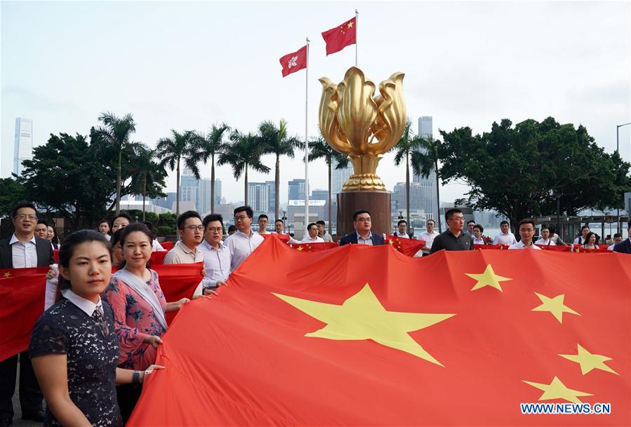 Los jóvenes sostienen la bandera nacional de China durante la flash mob en Hong Kong