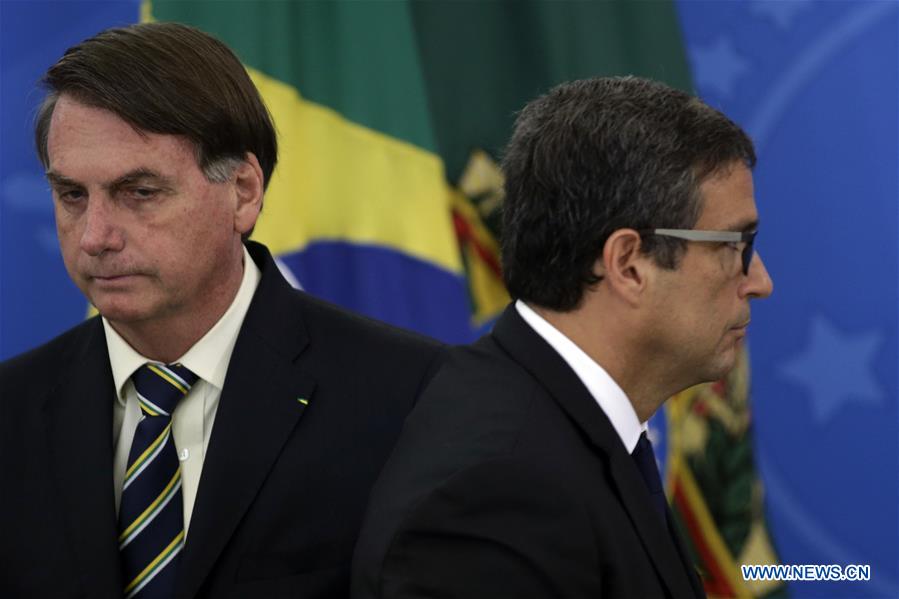 BRASILIA, 27 marzo, 2020 (Xinhua) -- El presidente de Brasil, Jair Bolsonaro (i), y el presidente del Banco Central brasile?o, Roberto Campos Neto (d), asisten a una conferencia de prensa para anunciar las medidas económicas para combatir la enfermedad provocada por el nuevo coronavirus (COVID-19), en el Palacio de Planalto, en Brasilia, Brasil, el 27 de marzo de 2020. El gobierno de Brasil anunció el viernes un programa de auxilio a peque?as y medianas empresas con líneas de financiamiento para el pago de salarios y mantener así el empleo en el sector. El programa ayudará a los ingresos de un porcentaje importante de la fuerza de trabajo durante la fase crítica por la epidemia del nuevo coronavirus. (Xinhua/Lucio Tavora)