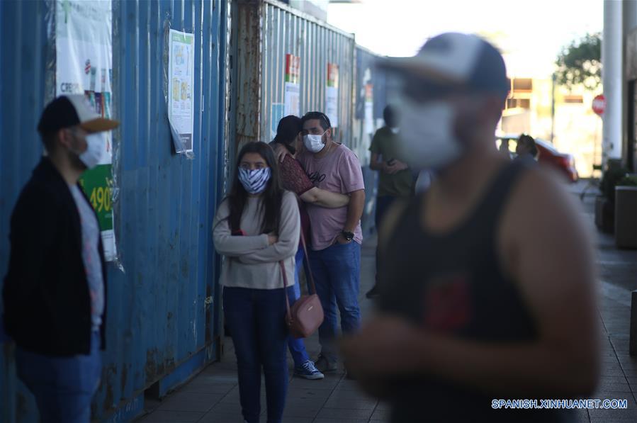 CHILLAN, 29 marzo, 2020 (Xinhua) -- Personas portando mascarillas hacen fila para entrar a un supermercado, en la ciudad de Chillán, en la región de ?uble, Chile, el 29 de marzo de 2020. El gobierno de Chile informó el domingo que existen 2.139 casos confirmados de la enfermedad causada por el nuevo coronavirus (COVID-19) y siete víctimas mortales de la enfermedad en el país. (Xinhua/Str)