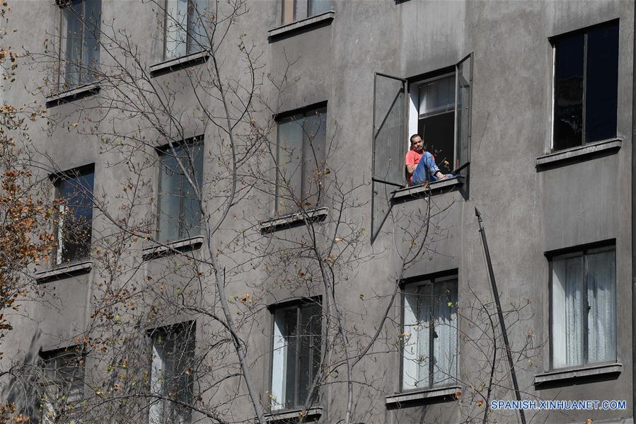 SANTIAGO, 13 abril, 2020 (Xinhua) -- Una persona observa desde la ventana de un edificio, en Santiago, capital de Chile, el 13 de abril de 2020. El Ministerio de Salud de Chile elevó el lunes a 7.525 el número de casos de la enfermedad causada por el nuevo coronavirus (COVID-19) en el país sudamericano, con 82 muertos a la fecha. (Xinhua/Jorge Villegas)