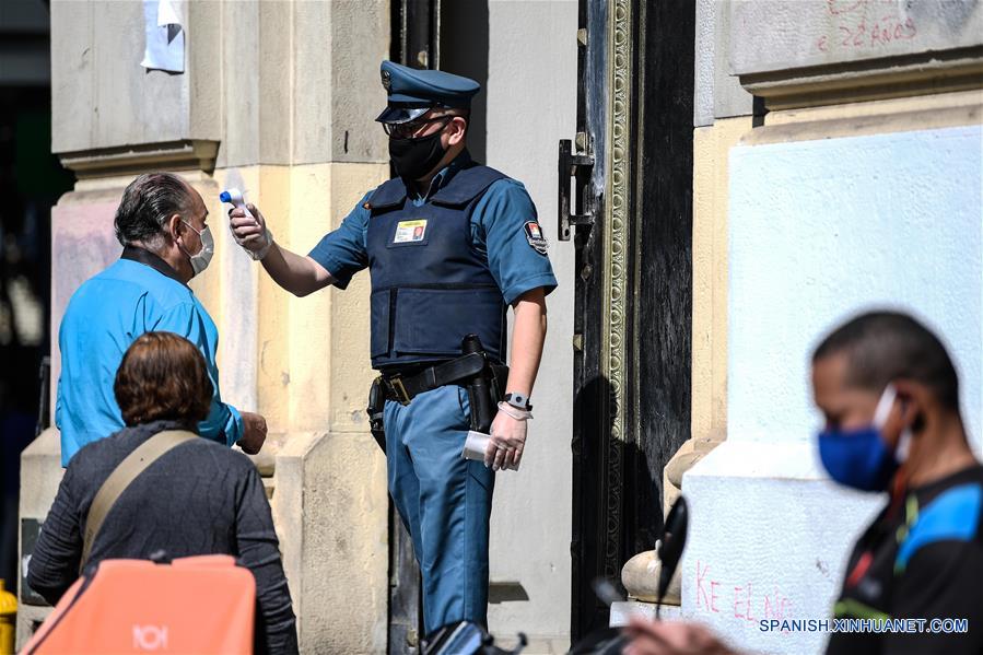 SANTIAGO, 13 abril, 2020 (Xinhua) -- Un guardia toma la temperatura corporal de un hombre antes de entrar a una sucursal bancaria en Santiago, capital de Chile, el 13 de abril de 2020. El Ministerio de Salud de Chile elevó el lunes a 7.525 el número de casos de la enfermedad causada por el nuevo coronavirus (COVID-19) en el país sudamericano, con 82 muertos a la fecha. (Xinhua/Jorge Villegas)