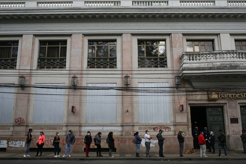 Varias personas hacen fila antes de ingresar a una sucursal bancaria en la ciudad de Chillán de la región de ?uble, en Chile, el 23 de abril de 2020. (Xinhua/Str)