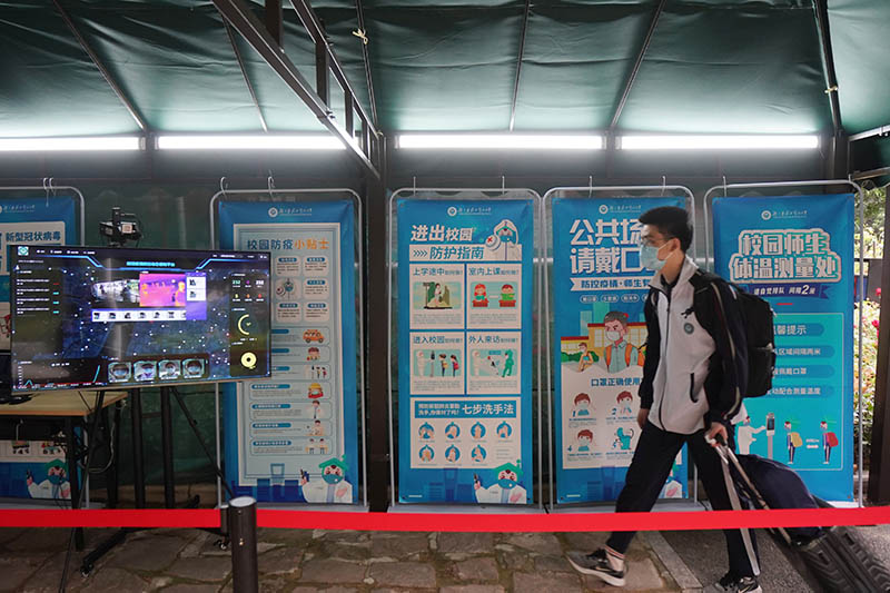 La foto tomada, el 6 de mayo de 2020, muestra a un estudiante de último a?o caminando a través de una estación de verificación de temperatura para ingresar en la Escuela Secundaria Experimental de Hubei Wuchang en Wuhan, capital de la provincia central china de Hubei. (Xinhua/Xiong Qi)