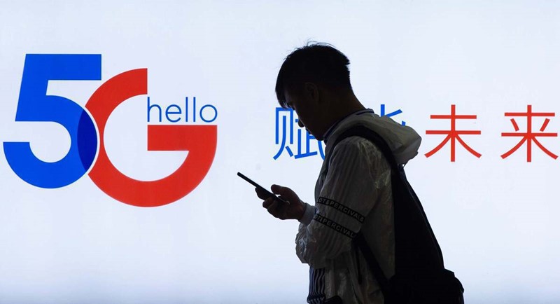 Un viandante pasa por delante de una promoción del sistema 5G. [Foto: Su Yang/China Daily]