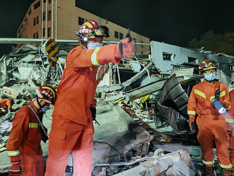 Los bomberos de la Brigada de Bomberos de Wenzhou buscan debajo de los escombros en el lugar de la explosión de un camión cisterna en Zhejiang. [Foto proporcionada a China Daily]