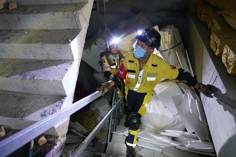 Miembros del equipo de rescate entran en un edificio da?ado en el lugar de la explosión de un camión en Zhejiang. [Foto proporcionada a China Daily]