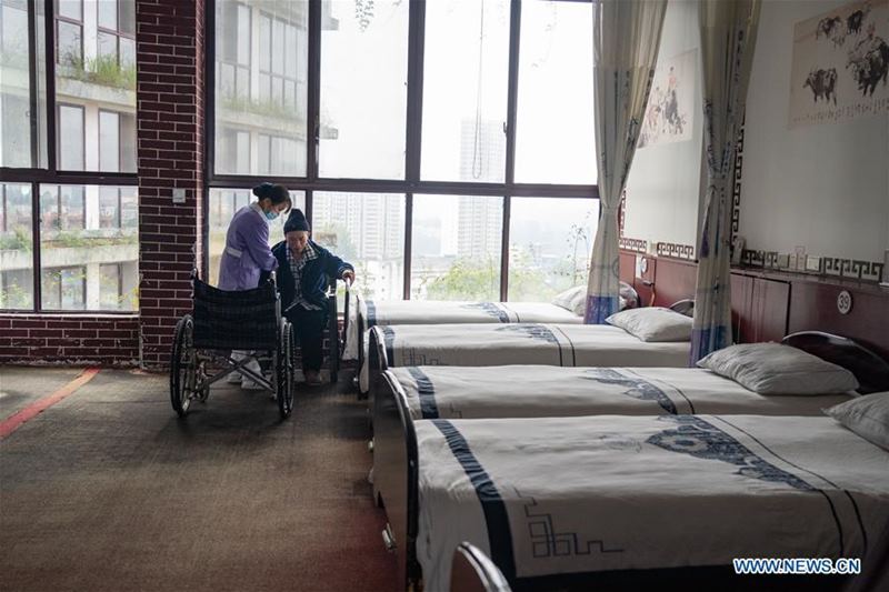 Un trabajador de la salud asiste a un anciano discapacitado en la residencia geriátrica del Hospital Longhui-Weiyuan, condado de Longhui, provincia de Hunan, 12 de octubre del 2020. Para elevar la calidad de la atención al adulto mayor, la unidad geriátrica proporciona servicios de enfermería, rehabilitación, entretenimiento y alimentación. (Fotos: Xinhua)