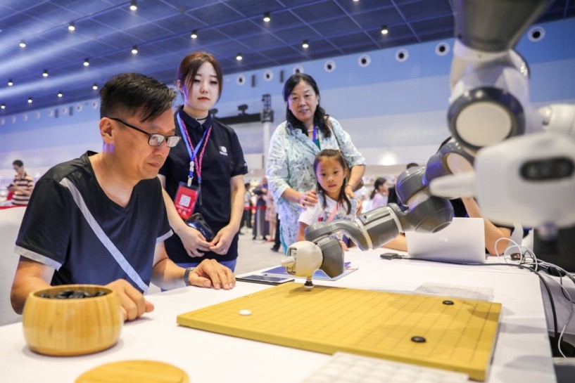 Un entusiasta del Weiqi juega contra un robot con inteligencia artificial en la ceremonia de apertura del Congreso Chino de Weiqi, 19 de agosto del 2019. (Foto: Diario del Pueblo/ Li Dawei)