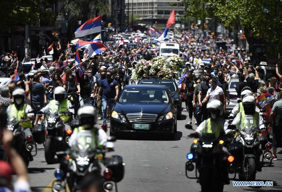 MONTEVIDEO, 6 diciembre, 2020 (Xinhua) -- Personas observan el paso del cortejo fúnebre con los restos del expresidente uruguayo Tabaré Vázquez, en la avenida 18 de Julio, en Montevideo, capital de Uruguay, el 6 de diciembre de 2020. Tabaré Vázquez murió el domingo a los 80 a?os de edad a raíz de un cáncer de pulmón detectado en agosto de 2019 y a ocho meses de haber finalizado su segundo mandato presidencial, confirmó su familia. (Xinhua/Nicolás Celaya)