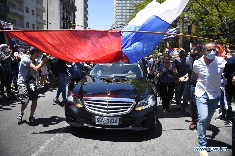 MONTEVIDEO, 6 diciembre, 2020 (Xinhua) -- Personas reaccionan mientras pasa el cortejo fúnebre con los restos del expresidente uruguayo Tabaré Vázquez, a las afueras de la Intendencia de Montevideo, en Montevideo, capital de Uruguay, el 6 de diciembre de 2020. Tabaré Vázquez murió el domingo a los 80 a?os de edad a raíz de un cáncer de pulmón detectado en agosto de 2019 y a ocho meses de haber finalizado su segundo mandato presidencial, confirmó su familia. (Xinhua/Nicolás Celaya)