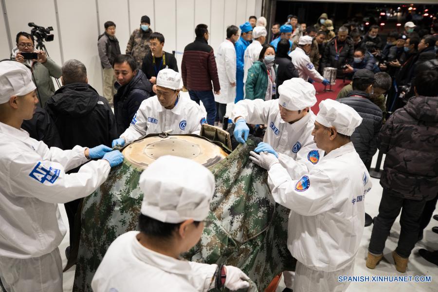 Imagen del 17 de diciembre de 2020 de investigadores científicos colocando una cubierta protectora para el retornador de la sonda espacial Chang'e-5 después de sacar el contenedor cargado con muestras lunares, en Beijing, capital de China. La sonda espacial Chang'e-5 de China trajo a la Tierra alrededor de 1.731 gramos de muestras tomadas en la Luna, según informó la Administración Nacional del Espacio de China. Los científicos llevarán a cabo el almacenamiento, análisis e investigación de las primeras muestras lunares recolectadas por China. (Xinhua/Jin Liwang)