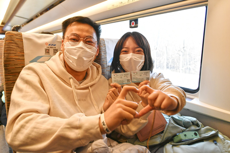 Los pasajeros se hacen fotos con sus billetes de tren en el primer ferrocarril que une Beijing y la Nueva área de Xiong′an, en la Estación de Ferrocarriles Oeste de Beijing, el 27 de diciembre de 2020. [Foto de Sun Lijun / chinadaily.com.cn]