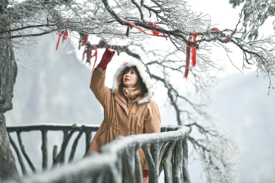 Un turista disfruta del encantador paisaje con escarcha en la monta?a Tianmen de la ciudad de Zhangjiajie, provincia de Hunan, el 14 de diciembre. [Foto de Shao Yin / Para China Daily]