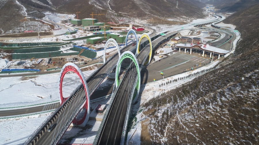 Un puente de carretera con dise?o de construcción de anillos olímpicos está rodeado por dunas de nieve en la aldea Taizicheng de la ciudad de Zhangjiakou, provincia de Hebei, el 27 de diciembre. [Foto de Chen Xiaodong / Para China Daily]