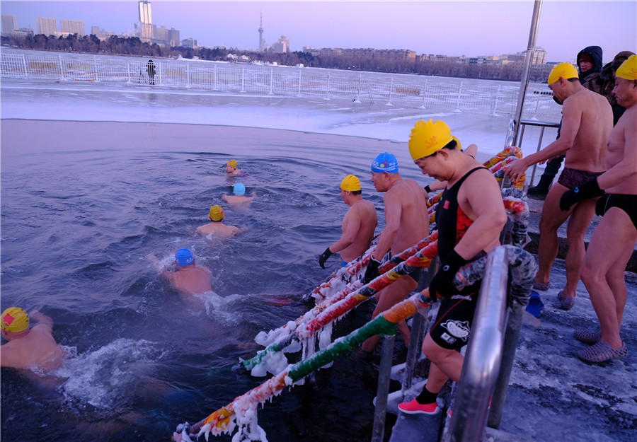 Los entusiastas de la natación de invierno se sumergen en el lago helado de Nanhu para expresar buenos deseos para el nuevo a?o en Changchun, provincia de Jilin, el viernes. [Foto proporcionada a chinadaily.com.cn]