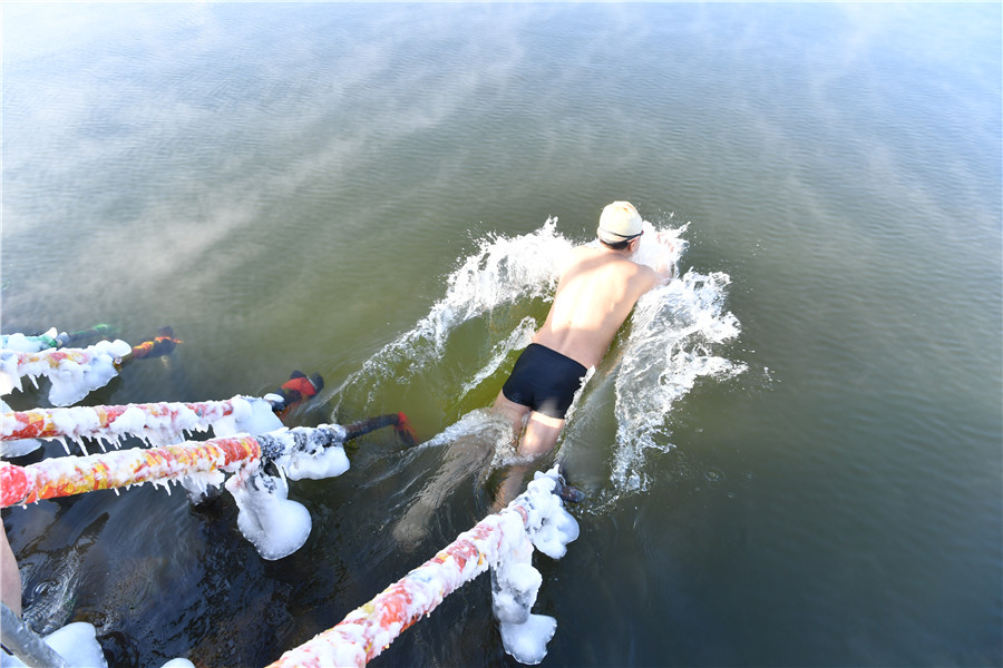 Un hombre se zambulle en el lago helado de Nanhu en Changchun, provincia de Jilin, el viernes. [Foto proporcionada a chinadaily.com.cn]