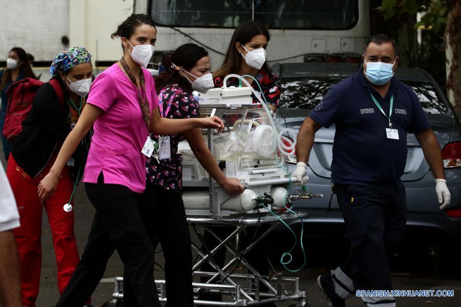 Personal médico evacúa a un paciente durante un incendio en el Hospital San Borja, en Santiago, capital de Chile, el 30 de enero de 2021. La Oficina Nacional de Emergencia de Chile reportó el sábado un incendio en el Hospital San Borja, ubicado en el centro de la capital, que obligó a evacuar a pacientes críticos, aunque no se registraron heridos. (Xinhua/Str)