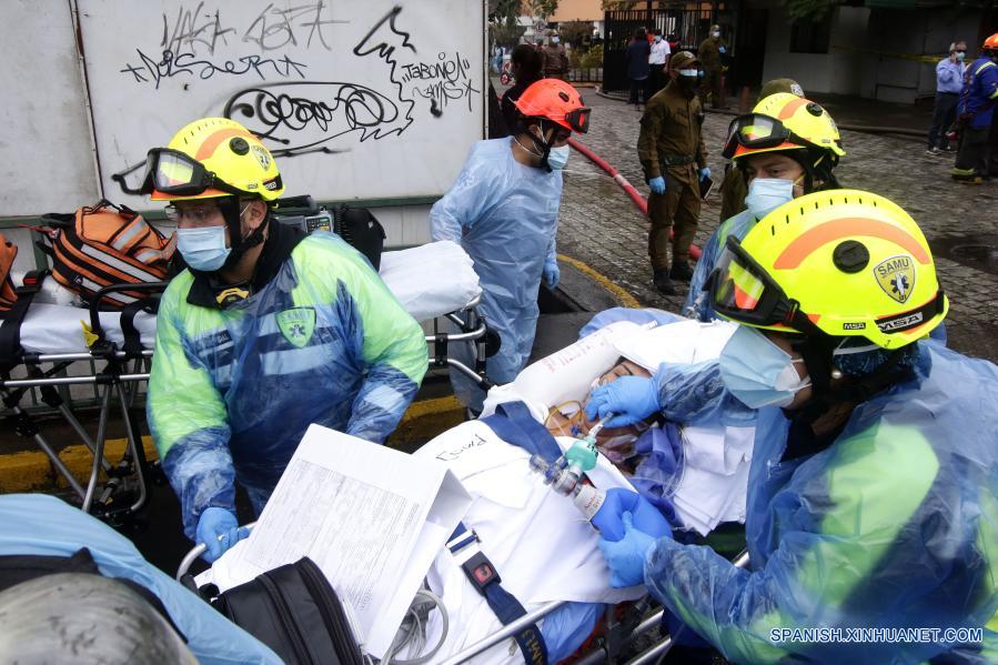 Elementos del Servicio de Atención Médica de Urgencias evacúan a un paciente durante un incendio en el Hospital San Borja, en Santiago, capital de Chile, el 30 de enero de 2021. La Oficina Nacional de Emergencia de Chile reportó el sábado un incendio en el Hospital San Borja, ubicado en el centro de la capital, que obligó a evacuar a pacientes críticos, aunque no se registraron heridos. (Xinhua/Str)