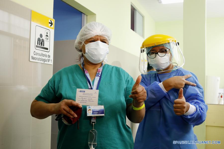 Una trabajadora de la salud (i) muestra una cartilla de vacunación después de recibir una vacuna del laboratorio chino Sinopharm contra la enfermedad del nuevo coronavirus (COVID-19), en el Hospital Nacional San Bartolomé, en Lima, Perú, el 9 de febrero de 2021. Perú inició el martes su primera etapa de vacunación contra la COVID-19, que incluye al personal de salud que recibirá los inmunizantes del laboratorio chino Sinopharm. (Xinhua/Mariana Bazo)