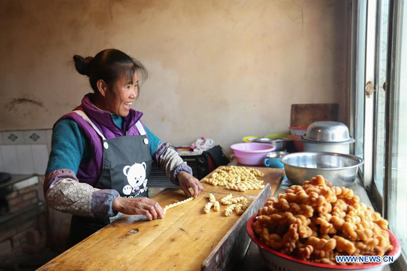 El aldeano Chen Jin'e prepara Mahua, un aperitivo de masa retorcida frita, antes del A?o Nuevo Chino en la aldea Yuangudui del condado Weiyuan, en Dingxi, provincia de Gansu, noroeste de China, el 6 de febrero de 2021. [Foto / Xinhua]