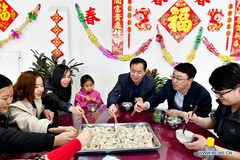 Los trabajadores ferroviarios que optaron por no viajar durante el A?o Nuevo Chino para frenar la propagación de COVID-19 disfrutan de una comida hecha a base de bolas de masa en Jinan, provincia de Shandong, en el este de China, el 10 de febrero de 2021. [Foto / Xinhua]