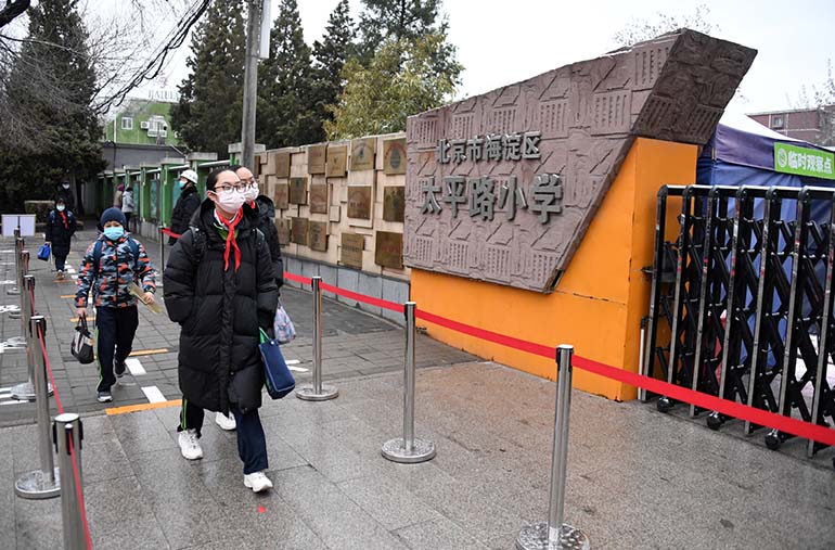 Los estudiantes caminan hacia la escuela para comenzar el semestre de primavera presencial del distrito Haidian de Beijing, el 1 de marzo de 2021. [Foto / Xinhua]