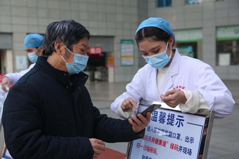 El 28 de enero de 2021, el personal médico y los voluntarios ayudan a los pacientes ancianos a escanear el código de salud antes de ser entrar al Hospital de Medicina Tradicional China y Medicina Occidental en la ciudad de Panzhihua, provincia de Sichuan (en el suroeste de China). (Yin Yuan / Pueblo en Línea)