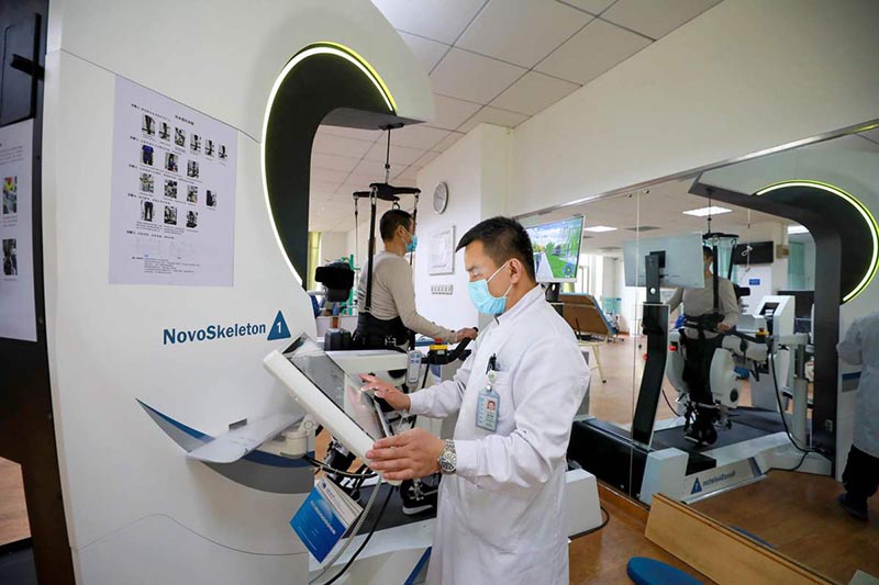 Los pacientes reciben terapia con un robot de rehabilitación de los miembros inferiores en el Hospital General de Aviación de la Universidad Médica de China en Beijing. [Foto de Zhang Jianfang / para chinadaily.com.cn]