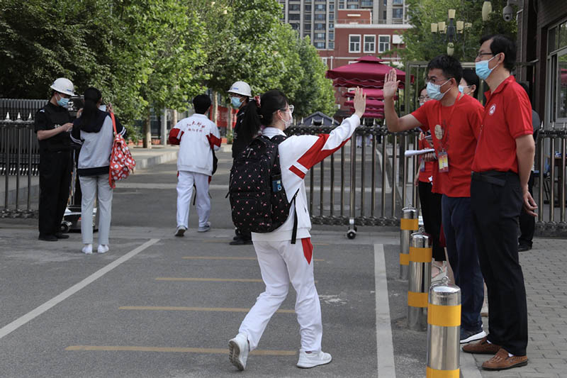 Un maestro anima a una estudiante que se presentará al Examen Nacional de Ingreso a la Universidad, Beijing, 7 de junio del 2021. [Foto: Wang Jing/ China Daily]