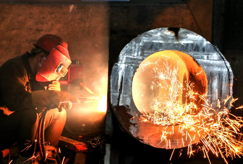 Un empleado fabrica un cilindro para una turbina de vapor en una planta de producción de maquinaria pesada en Huzhou, provincia de Zhejiang, el 2 de enero de 2021. [Foto de Yao Haixiang / Para China Daily]