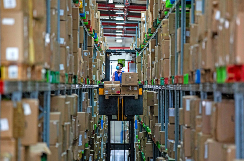 Un trabajador clasifica cajas de productos en un centro logístico en Cixi, provincia de Zhejiang, el 4 de noviembre de 2020. [Foto de Zhang Yongtao / Para China Daily]