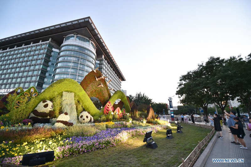 Personas toman fotos de las decoraciones florales que embellece la capitalina avenida Chang'an, 19 de junio del 2021. [Foto: Xinhua]