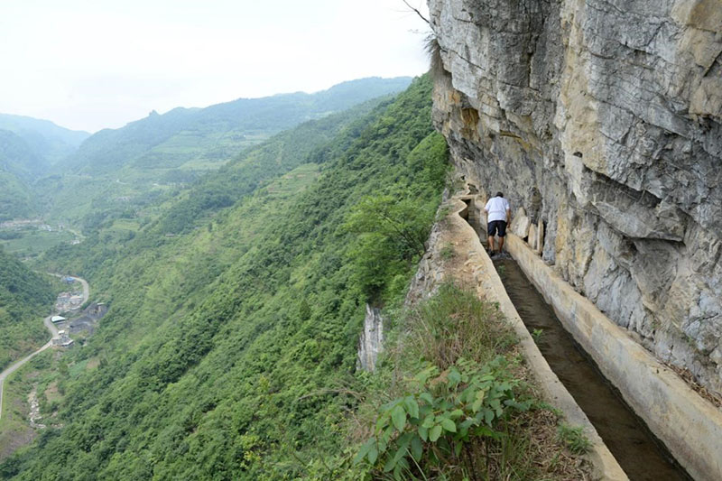 Huang Dafa patrulla y limpia el canal construido bajo su liderazgo, el 26 de junio de 2016. (Foto de Luo Xinghan / Pueblo en Línea)