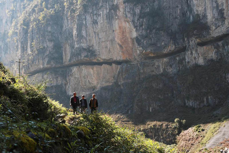 Los residentes revisan y limpian su camino construido a mano a lo largo de 470 metros de acantilados en la aldea de Shibanhe del condado Hezhang, provincia de Guizhou. [Foto de Han Xianpu / para chinadaily.com.cn]