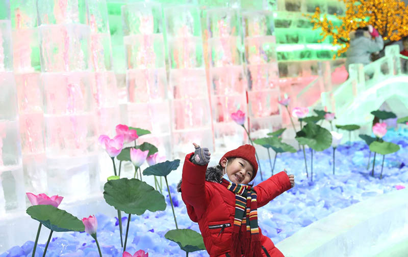 Un ni?o admira esculturas de hielo en la Garganta Longqing, 15 de enero del 2022. [Foto: Zou Hong/China Daily]