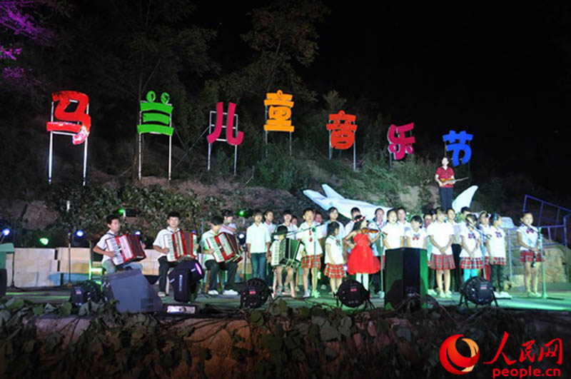 Deng Xiaolan y los ni?os de la aldea Malan cantan durante un concierto del 2013. (Foto: Pueblo en Línea/ Shen Yaxin)