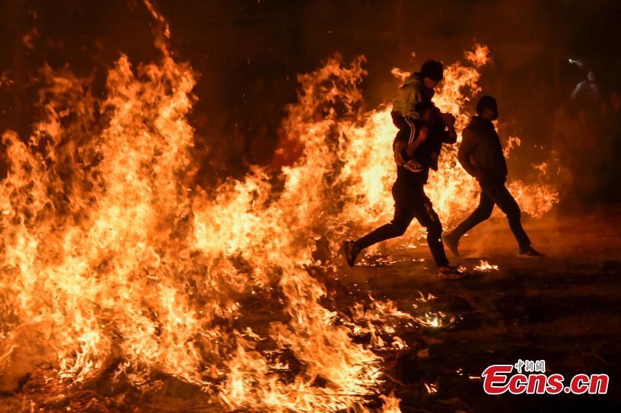 Haikou celebra la costumbre local de 'saltar sobre la hoguera' durante el Festival de los Faroles